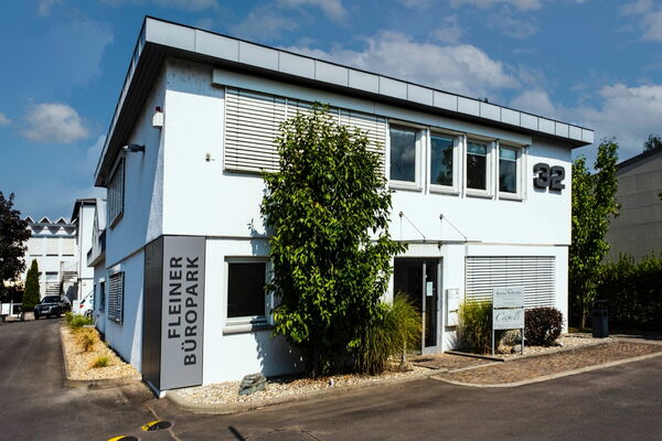 Zweigeschossiges weißes Bürogebäude mit der Hausnummer 32 und dem Schriftzug „Fleiner Büropark" an der Fassade